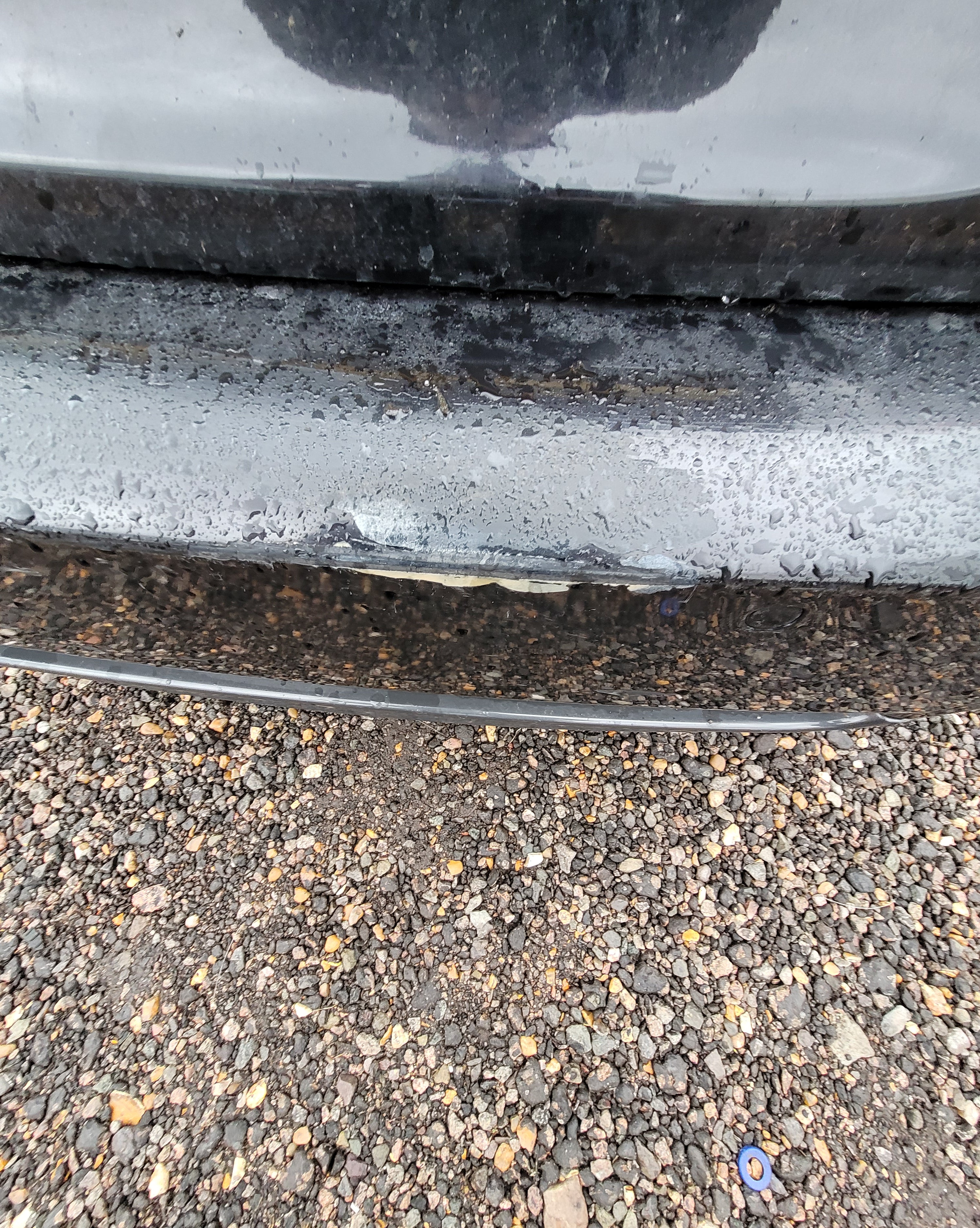 Metallic object on a textured asphalt surface