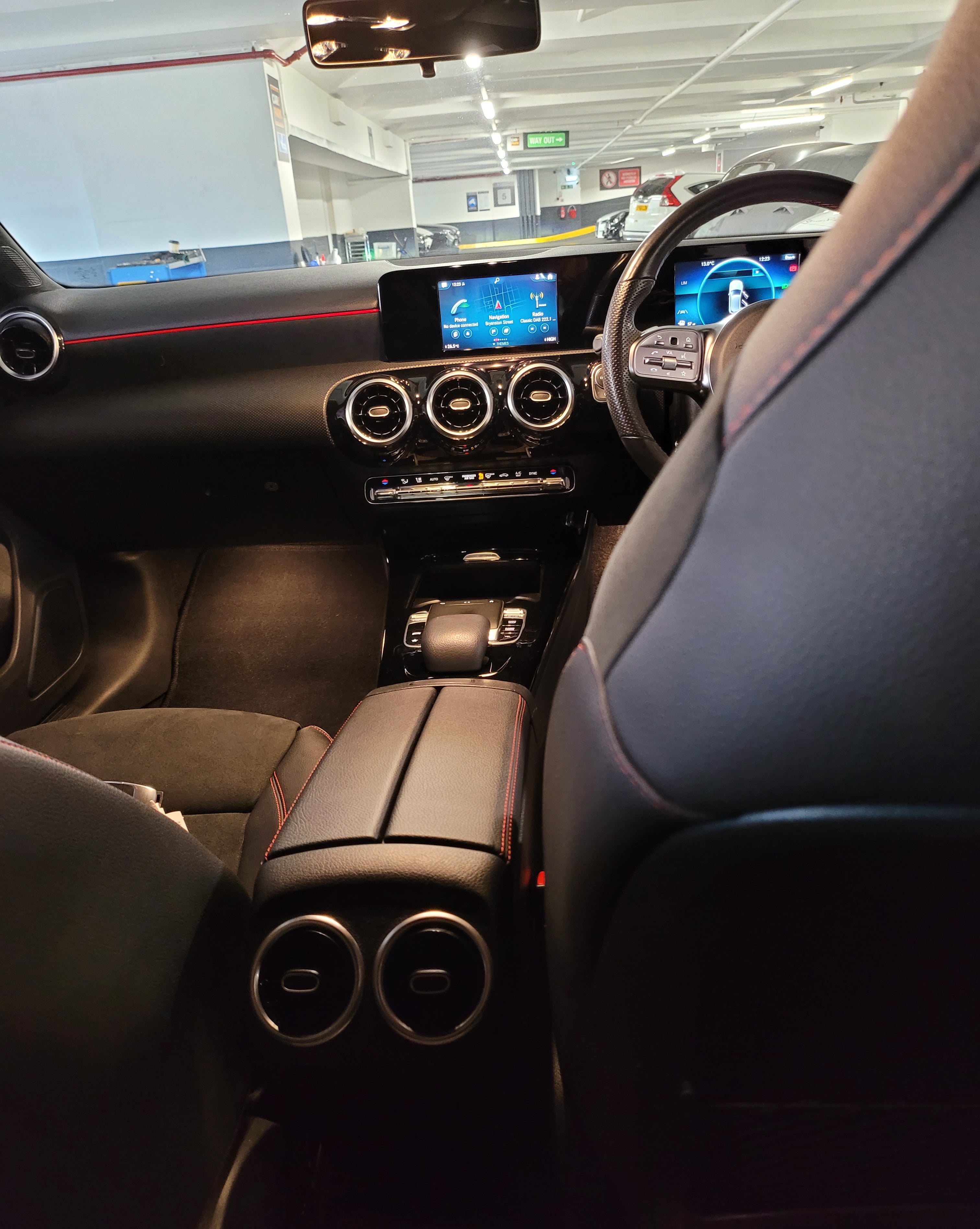 Car interior with dashboard, steering wheel, and center console.