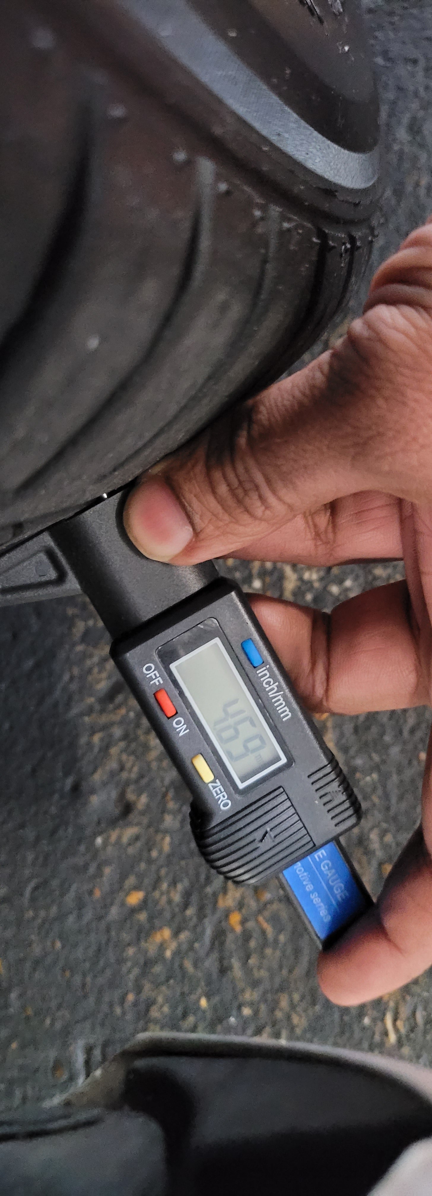 Digital tire pressure gauge being used on a tire